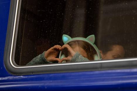 12. maaliskuuta otetussa kuvassa nuori tyttö näyttää ikkunan läpi sydänmerkkiä asemalaiturin suuntaan.