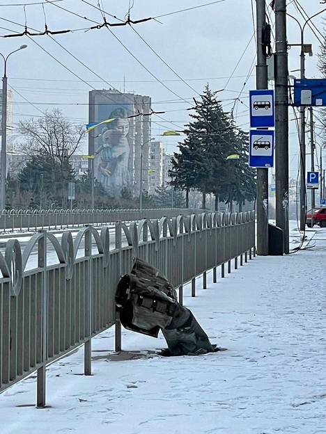 Novikova taltioi kaupungilla liikkuessaan puhelimellaan Mariupolin todellisuutta. Kuvan taustalla näkyvä muraali on kunnianosoitus tytölle, joka menetti vuonna 2015 äitinsä ja kätensä venäjämielisten separatistien raketti-iskussa. Etualalla on jalkakäytävään iskeytynyt raketti. 