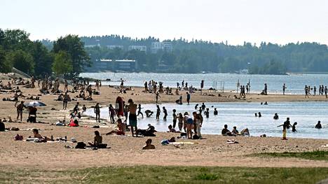Ihmiset nauttivat perjantaina helteistä Hietaniemen uimarannalla. Perjantai oli toukokuun 16. hellepäivä.