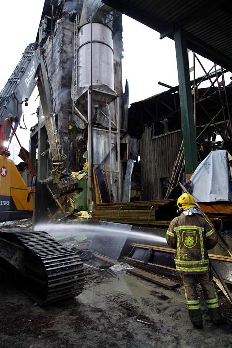 Raivaustyöt palaneella tehtaalla jatkuvat, ja välillä palomies letkuineen löytää sammutettavia pesäkkeitä.