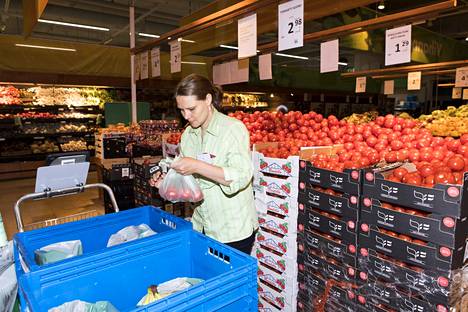 Heli Kosunen kerää kahden asiakkaan tilaamia ostoksia muovikasseihin kauppakeskus Kaaren Prismassa. Tomaatit laitetaan pussiin ja punnitaan normaaliin tapaan.