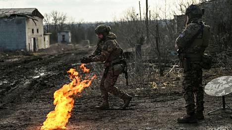 Ukrainalaiset sotilaat lämmittelivät ruudin avulla sytytetyn nuotion äärellä Bahmutissa 5. maaliskuuta. 