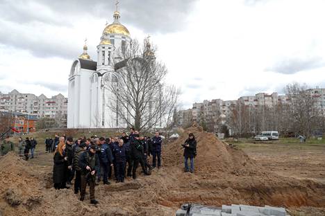 Ukrainaan sotarikoksia tutkimaan tulleet ranskalaiset seisoivat joukkohaudan äärellä Butshassa huhtikuussa. 