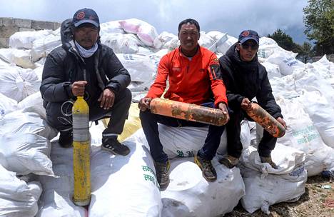 Mount Everestin rinteiltä on kerätty tänä vuonna myös tonneittain kiipeilijöiden jälkeensä jättämää roskaa. Siivoukseen osallistuneet nepalilaiskiipeilijät poseerasivat roskasäkkien päällä maanantaina.