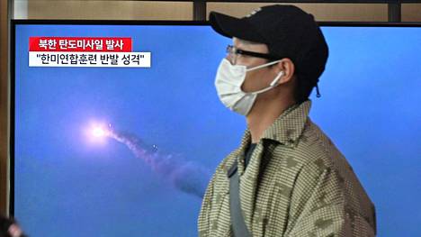 Mies käveli Pohjois-Korean ohjuskokeesta kertovan lähetyksen ohitse Etelä-Korean pääkaupunki Soulissa tiistaina.
