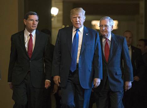 Yhdysvaltain presidentti Donald Trump marssi 28.11. Washingtonissa kongressitalon käytävällä rinnallaan senaatin enemmistöjohtaja Mitch McConnell (oik.) ja republikaanipoliitikko John Barrasso.