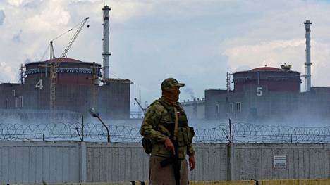 Venäjän lipulla varustettuun univormuun pukeutunut sotilas vartioi lähellä Zaporizzjan ydinvoimalaa 4. elokuuta.