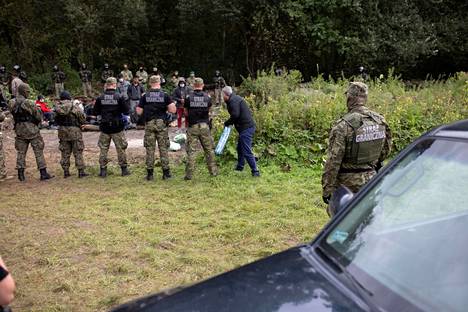 Puolalaiset rajavartijat vartioivat Valko-Venäjän puolelta tulleita rajanylittäjiä elokuun puolivälissä otetussa kuvassa.