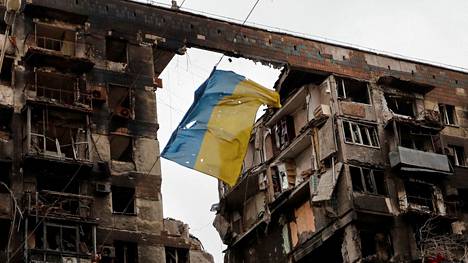 Rikki repeytynyt Ukrainan lippu liehui pommitetun kerrostalon edustalla. 