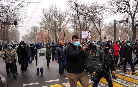 Mielenosoittajat marssivat kohti hallintorakennuksia Almatyssa keskiviikkona.