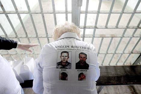 Anglinin veljesten sisar vieraili Alcatrazissa vuonna 2012, paidan selkämyksessä velipoikien vankilakuvat.