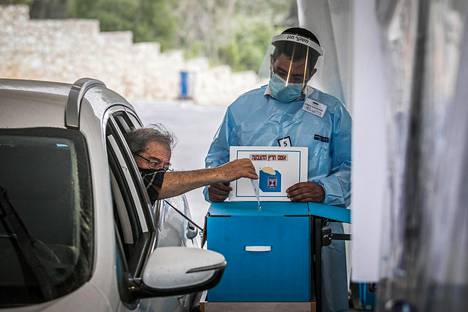 Mies äänestämässä autostaan Israelissa tiistaina 23. maaliskuuta.