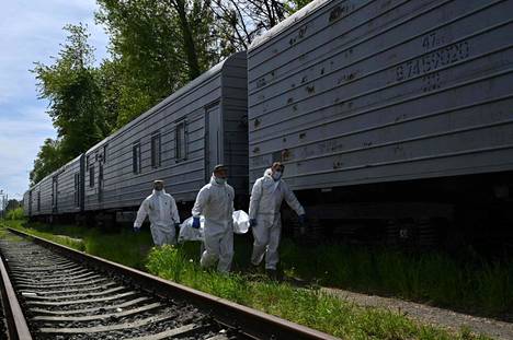 Ukrainalaiset kantoivat venäläisten ruumiita jäähdytettyihin junavaunuihin, joissa niitä säilytetään Zavalivkan kylässä. AFP:n mukaan ainakin 230 venäläissotilaan ruumiita säilytetään Ukrainan hallussa.