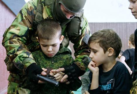Venäläismielinen taistelija opettaa lapsia käyttämään aseita kapinallisten hallitsemassa Donetskin ”kansantasavallassa” maaliskuun lopussa.