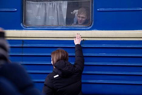 Nainen hyvästelee nuorukaisen Lvivin rautatieaseman laiturilla.