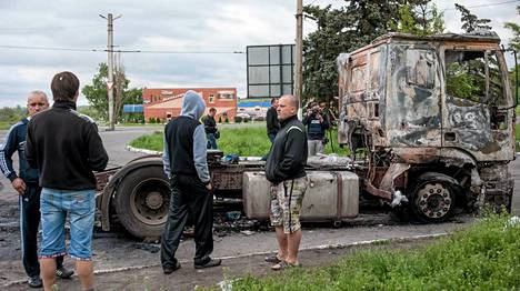 Ukrainalaiset ihmettelivät palanutta kuorma-autoa Slovjanskissa maanantaina.