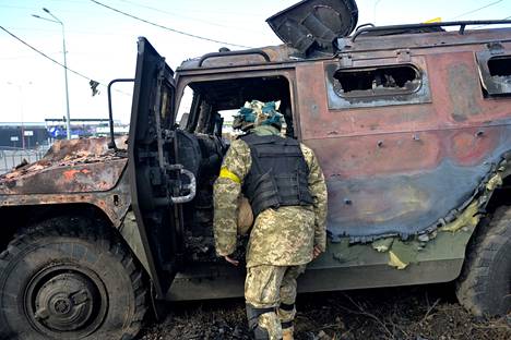 Venäjä on kärsinyt Ukrainan sodassa raskaita tappioita. Kuvassa ukranalaissotilas tutkimassa tuhoutunutta venäläistä kuljetuspanssariajoneuvoa.