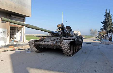 Turkin tukemat syyrialaistaistelijat etenivät tankilla Saraqebin kaupunkiin Idlibissä torstaina.