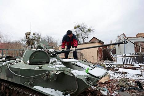 Butshan asukas tutki tuhottua panssarivaunua 1. maaliskuuta kaupunkinsa kadulla.