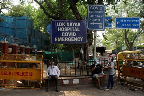 Hengitysvaikeuksista kärsivä koronapotilas istui Delhissä sijaitsevan Lok Nayak Jai Prakash Narayan -sairaalan edustalla keskiviikkona.
