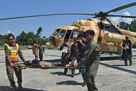 Pakistanin armeijan sotilaat kantoivat tiistaina paareilla turistia, joka pelastettiin helikopterilla tulvan runtelemalta turistialueelta Saidu Sharifista.
