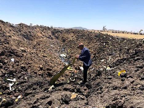 Mies tutkailee Addis Abeban lähistölle tänään sunnuntaina syöksyneen lentokoneen jäänteitä Etiopiassa.