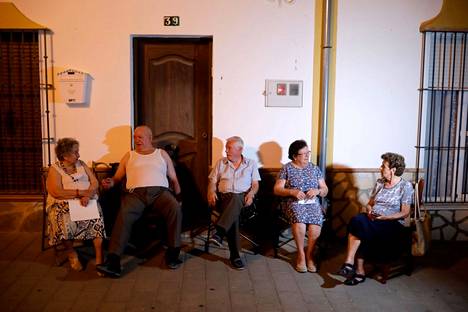 Päivän kuumuutta vältelleet naapuruston ikäihmiset istuivat illalla ulkona Algarin kylässä Espanjaa viime elokuussa riivanneen helleaallon aikana.