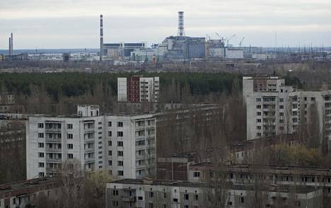 Tshernobylin ydinvoimala siintää horisontissa. Nykyään sen päälle on rakennettu uusi suojakuori. Kuva vuodelta 2006.