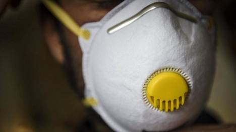 Mies käyttää FFP2 -hengityssuojainta suojatakseen itsensä koronavirustartunnalta Helsingissä 16. huhtikuuta 2020.