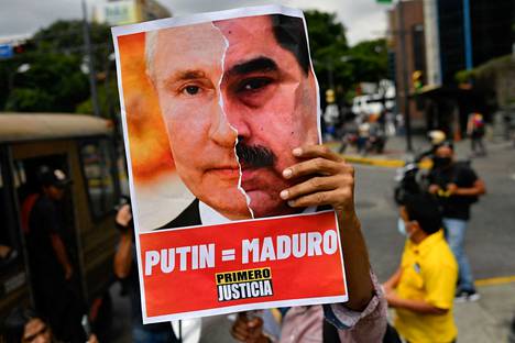 Venezuelalaiset mielenosoittajat yhdistävän Putinin ja Nicolas  Maduron kuvat. Yhdysvallat on kuitenkin nyt valmis neuvottelemaan Maduron kanssa, jotta öljyä saataisiin lisää markkinoille.