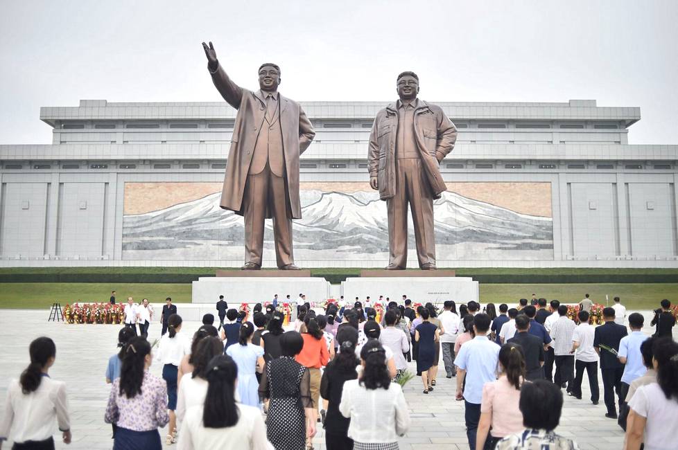 Kansalaisia Kim Il-sungin ja Kim Jong-ilin patsailla Pyongyangissa.