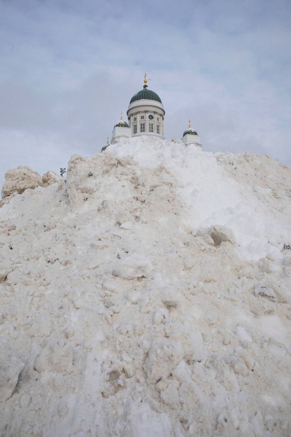 Tammikuinen lumikaaos Valtteri-myrskyn jäljiltä. Tuomiokirkko pilkistää valtavan lumikasan huipulta.