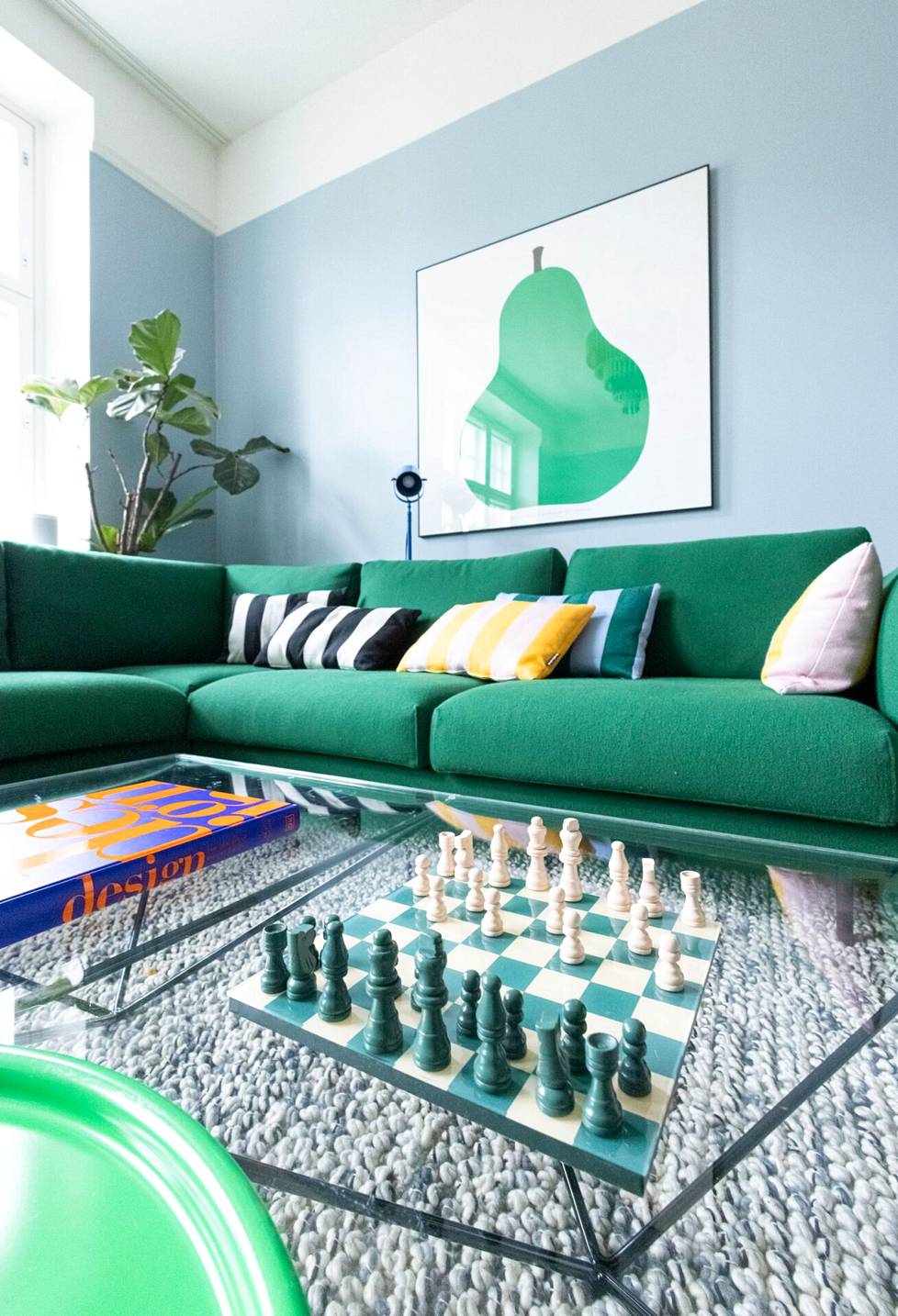 Sinisen ja vihreän yhdistelmä on Annaleena Hakolan mieleen tällä hetkellä. Värimaailma toistuu kodissa. Tyynyt sohvalla ovat Hakolan omasta mallistosta, ja ne on päällystetty Vuokko Nurmesniemen suunnittelemalla kuosilla.
