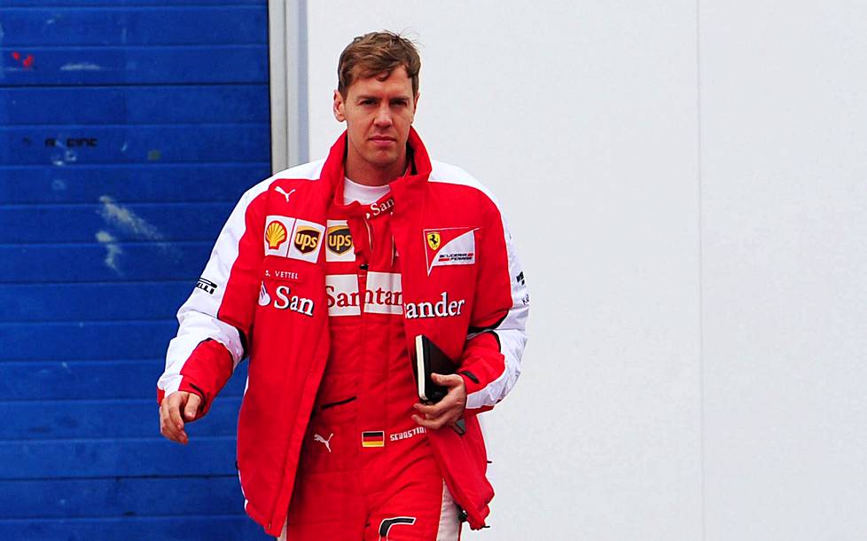 Tuttu näky varikolla: Sebastian Vettel ja mustakantinen muistivihkonsa.