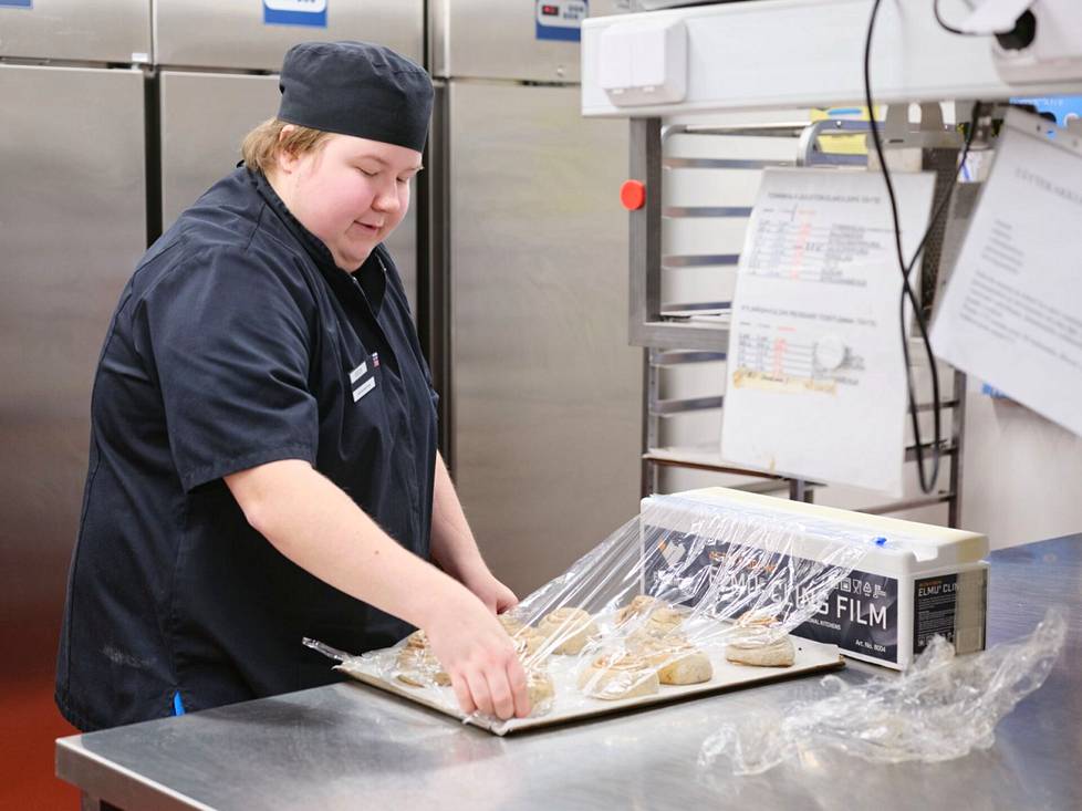 Kahvilassa Valorinta tekee töitä sekä keittiössä että kassalla asiakkaita palvellen.