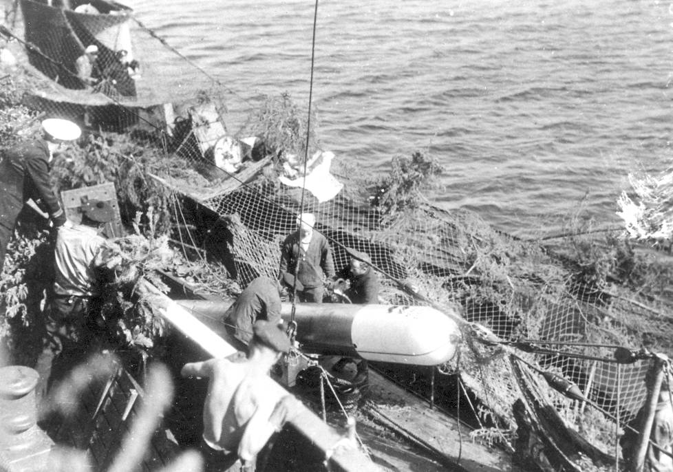 Aina ei oltu taistelemassa. Vetehisen miehistö viettää kesäpäivää tukikohdassa ilmeisesti kesällä 1943.–Minut hälytettiin uimasta kameran eteen, kuvassa oikealla istuva Kauko Ritaluoma muistelee.