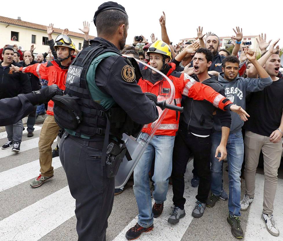 Palomiehet pyrkivät turvaamaan äänestäjien pääsyn äänestyspaikalle Sant Julia de Ramisin urheilukeskukseen Gironassa.