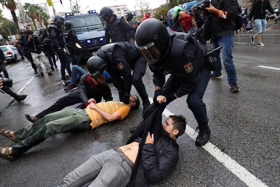 Guardia Civil -santarmit raahasivat mielenosoittajia äänestyspaikan lähistöllä Barcelonassa.