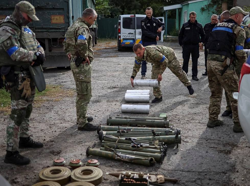 Miinanraivaaja asetteli riviin lieriöitä, joissa POM-3-miinoja säilytetään. Ne löytyivät Harkovan alueelta Udyn kylästä, jonka Ukraina vapautti viime syksynä. Etualalla näkyi myös panssarimiinoja sekä pienempiä henkilömiinoja.