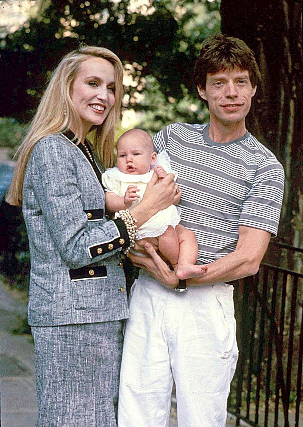 Jerry Hall ja Mick Jagger Elizabeth-tyttärensä kanssa 1984.