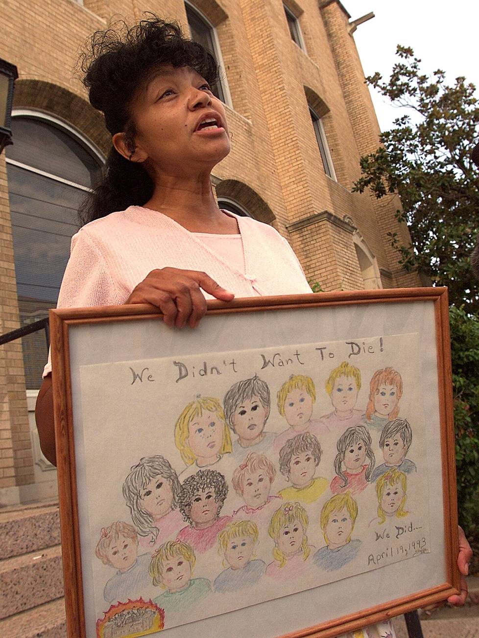 Daavidin oksaan kuulunut Sheila Martin piteli lapsiuhreista muistuttavaa kylttiä Wacon oikeustalon ulkopuolella heinäkuussa 2000. Hän menetti miehensä ja neljä seitsemästä lapsestaan tragediassa.