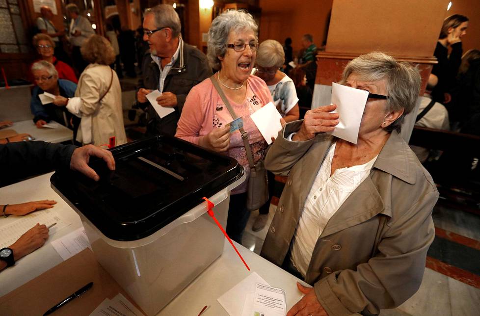 Nainen suuteli äänestyslipuketta ennen kuin pudotti sen vaaliuurnaan Barcelonassa.