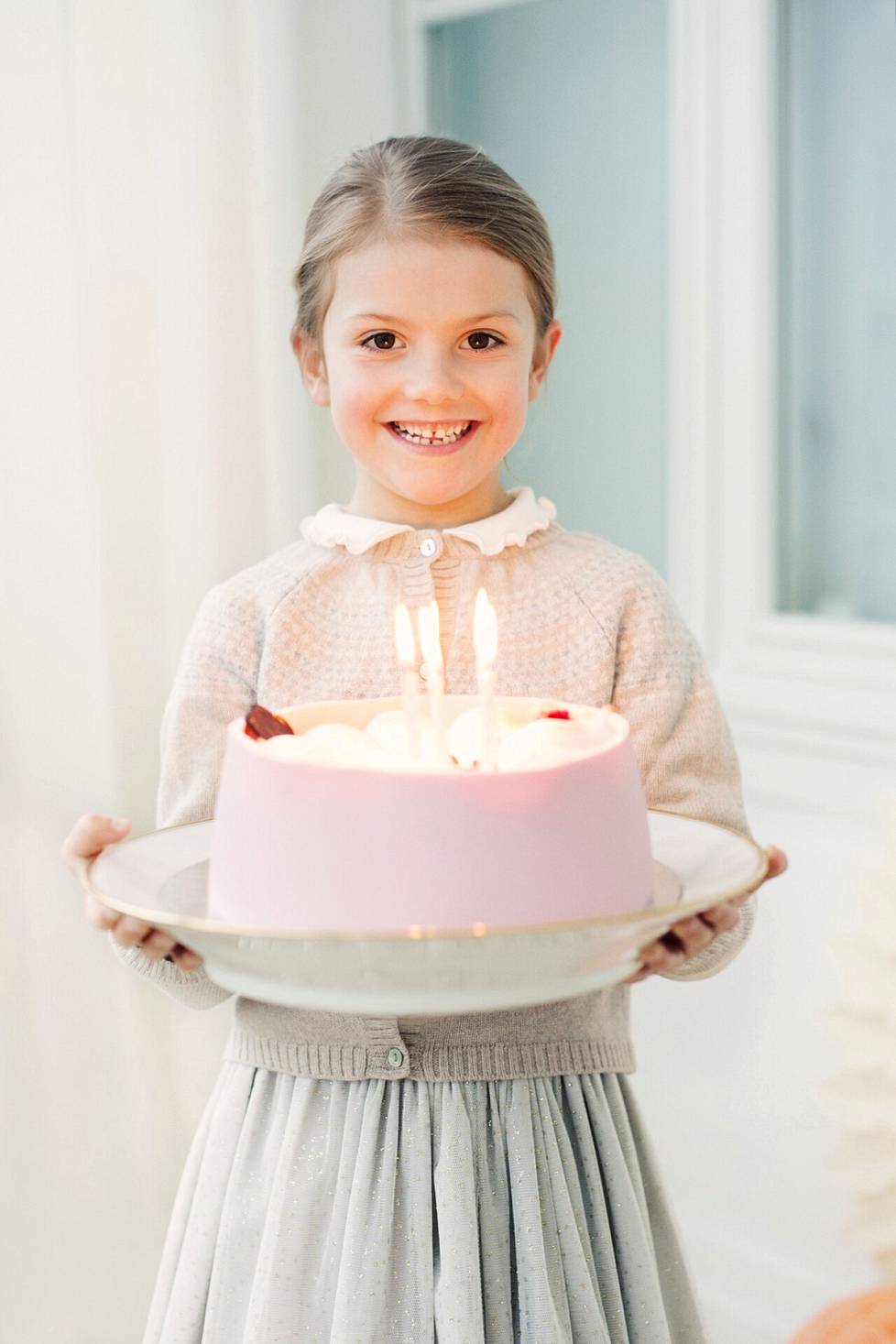 Syntymäpäiväsankari ja kuuden kynttilän kakku vuonna 2018.