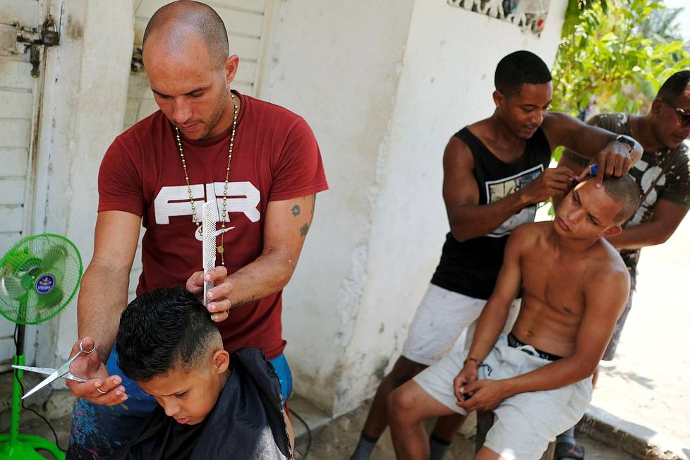 Tukka hyvin.  Hondurasilaismiehet leikkauttivat hiuksiaan Meksikon Chiapasissa, jossa he odottavat tietoa anomastaan humanitaarisesta viisumista Yhdysvaltoihin.