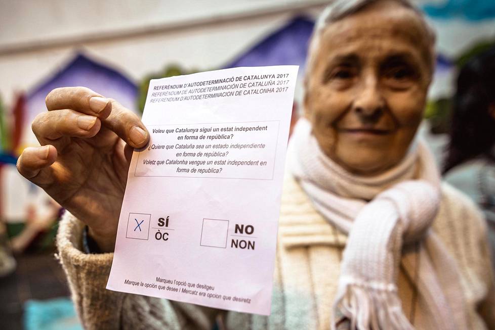 Nainen jonotti valmiiksi täytetyn äänestyslipun kanssa pääsyä äänestyspaikalle Francesc Macia -koululle Barcelonassa.