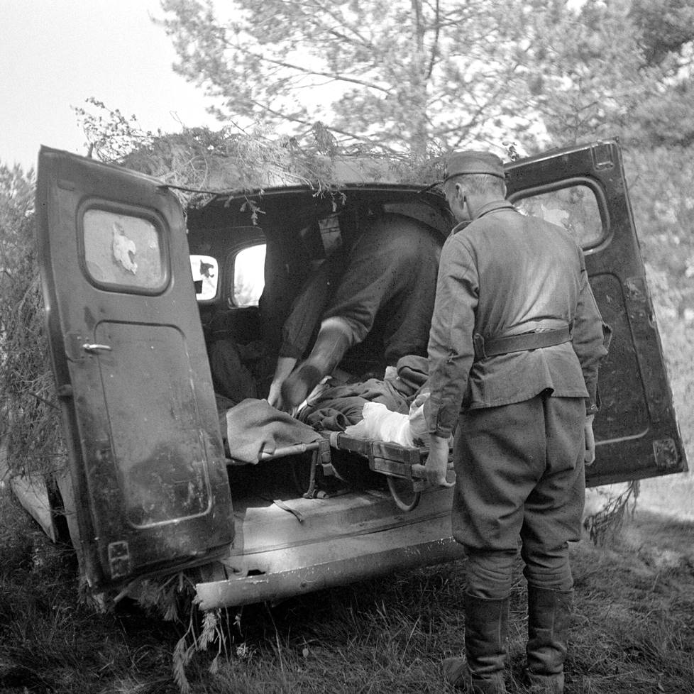 Haavoittuneita sotilaita kuljetetaan kenttäsairaalaan (oik), kuva Salmin maastosta 1944.