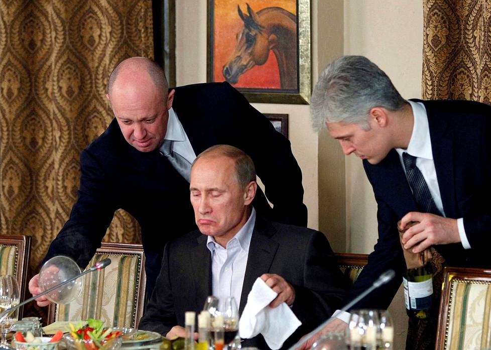 Kuin kummisedän pöydässä. Jevgeni Prigozhin (vas.) avusti Vladimir Putinia illallisella Cheval Blanc -ravintolassa Moskovan liepeillä marraskuussa 2011. Putin oli tuolloin pääministeri ja isännöi ulkomaalaisia opiskelijoita sekä journalisteja.