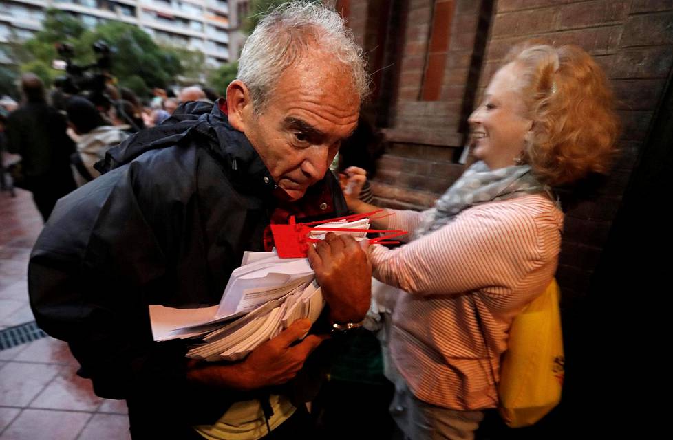 Mies kantoi äänestyslipukkeita äänestyspaikalle Barcelonassa.