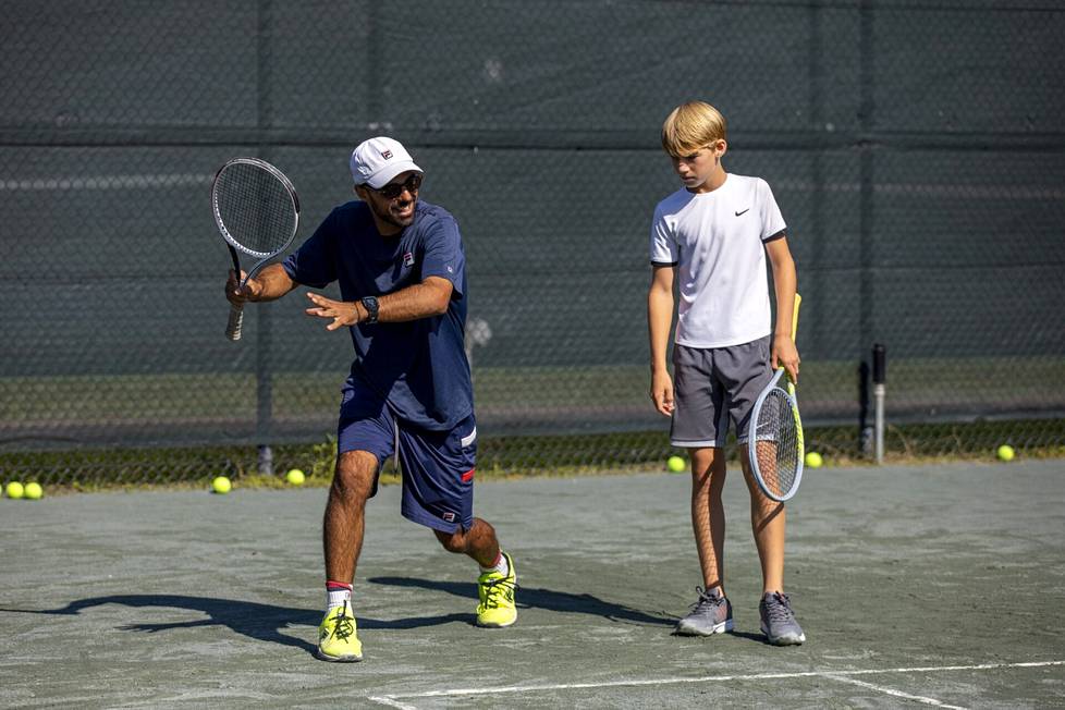 Valmentaja Tiago Bastos opasti Matthew Kringeriä, 14, JTCC-tenniskeskuksessa College Parkissa.