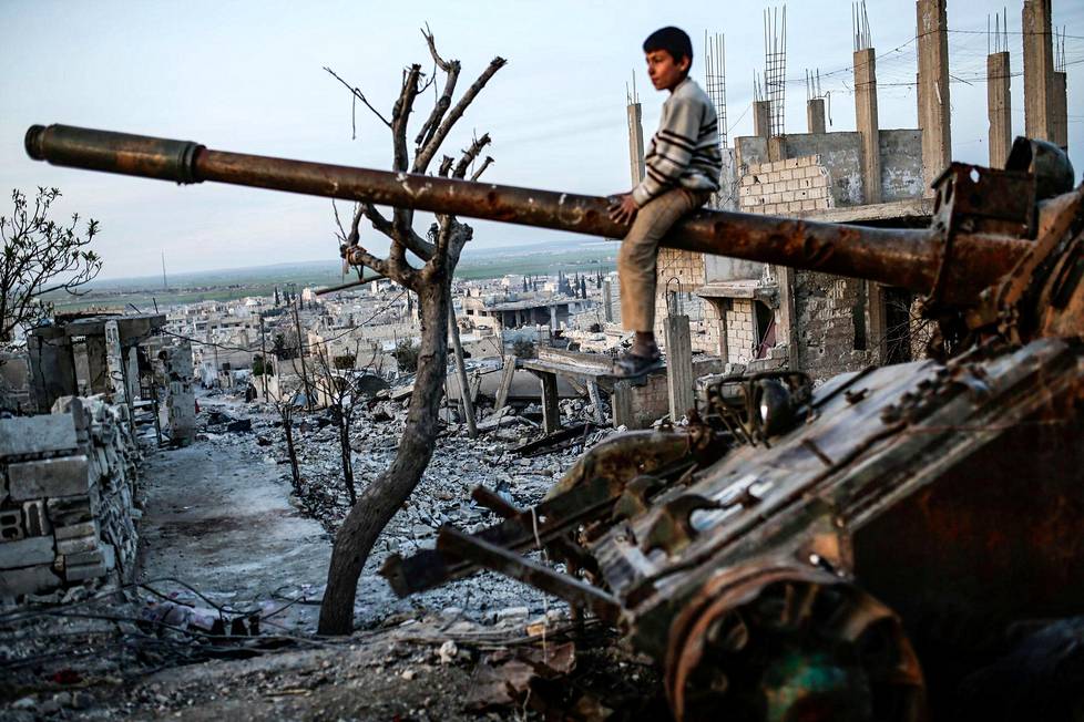 Maaliskuussa 2015 syyrialainen kurdipoika istui tuhoutuneen tankin päällä Kobanen kaupungissa. Kurdien YPG-joukot olivat ajaneet Isisin kaupungista kaksi kuukautta aiemmin.